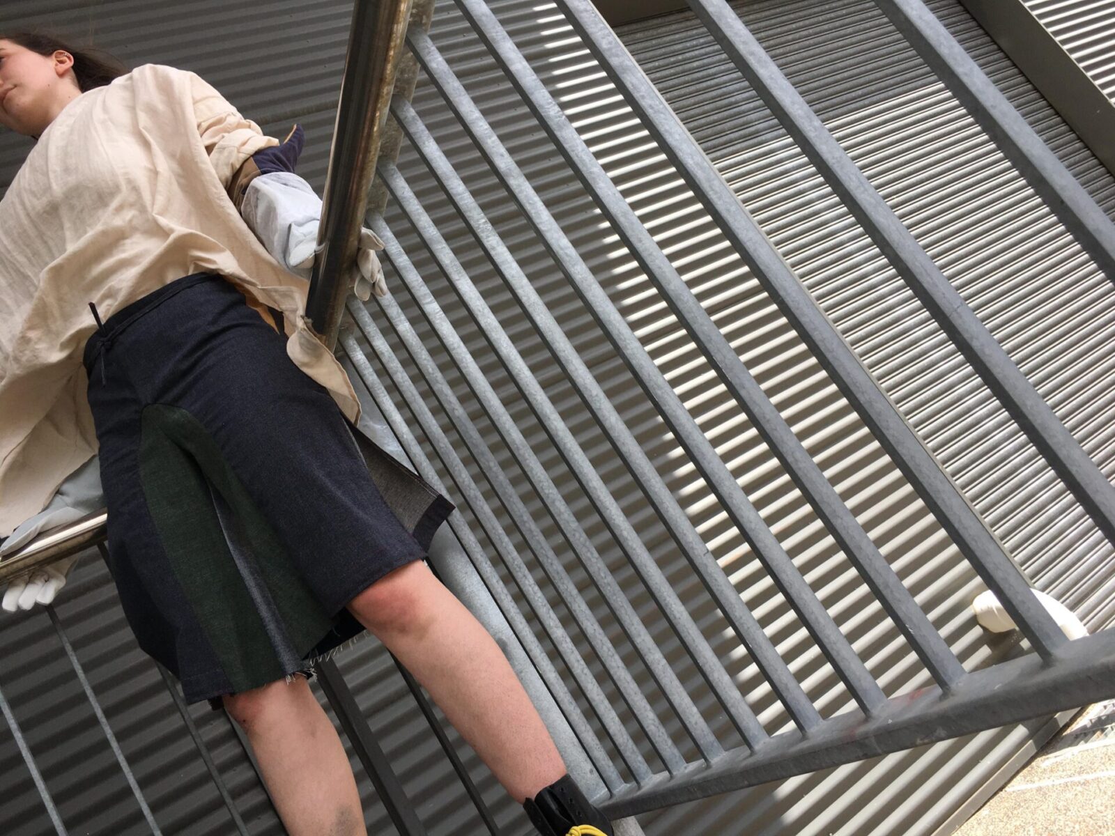 Person wearing shorts and shirt leaning on banister.